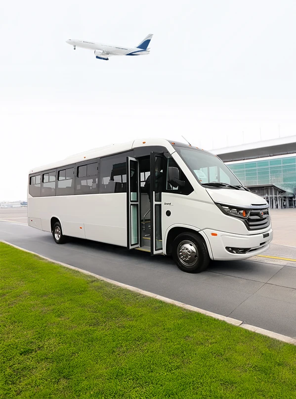 white shuttle bus parked in front of an airport building