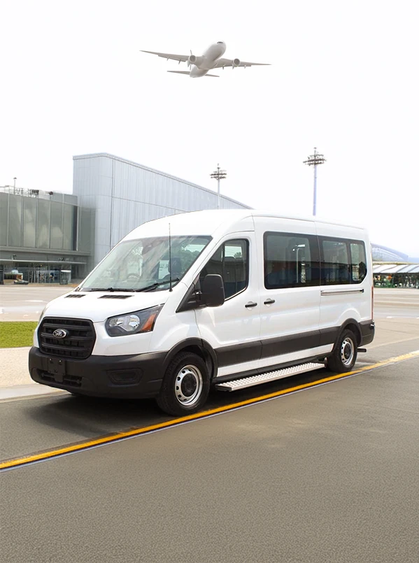 white passenger van parked in front of an airport