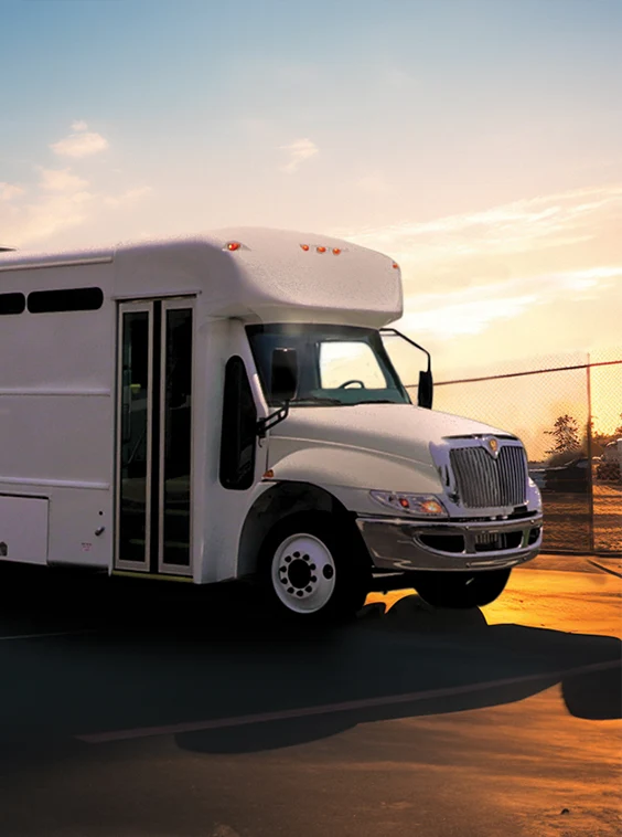 White shuttle bus parked next to a security fence at a prison near Texas